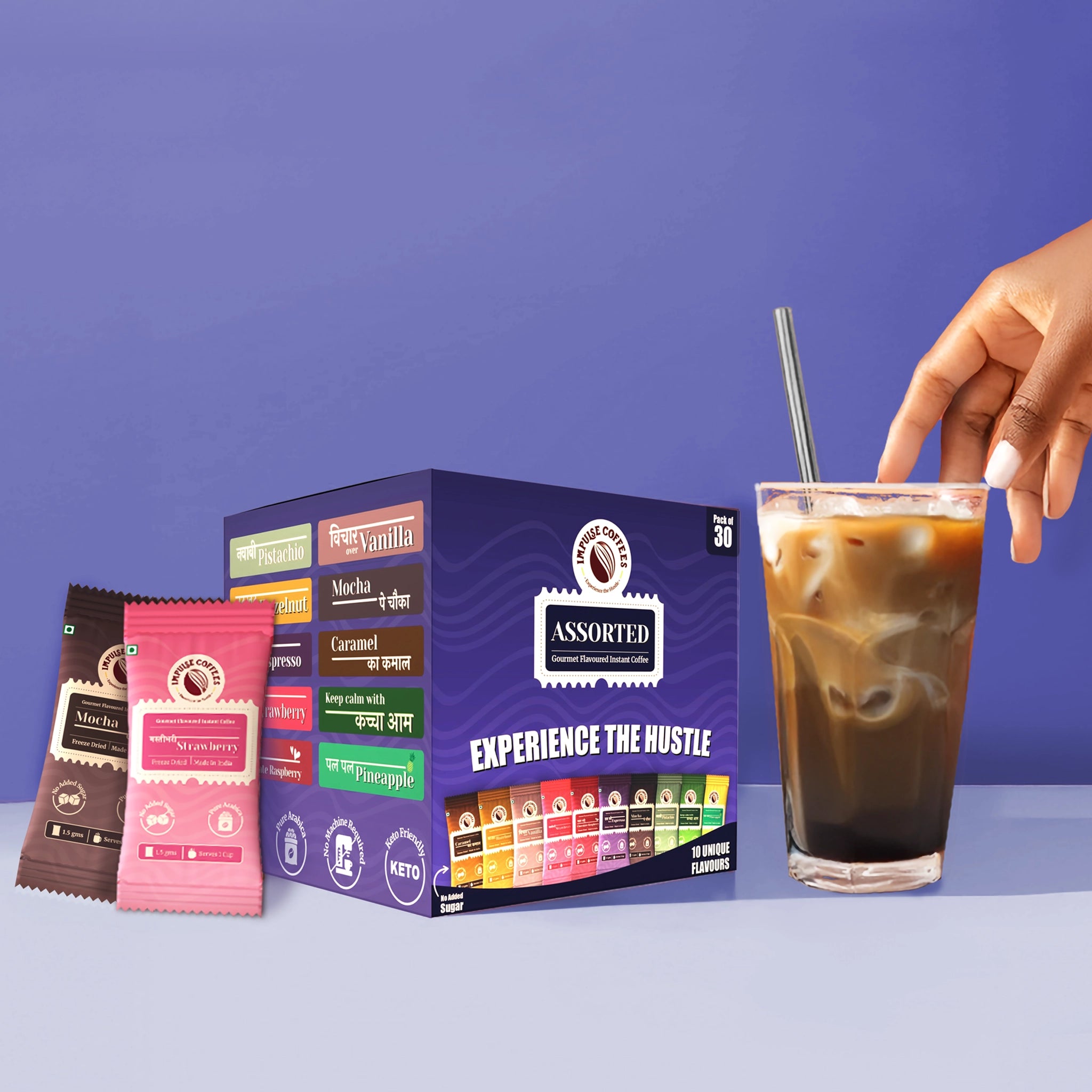 Impulse Coffees Assorted Pack of 30. Features the purple Pack of 30 box alongside individual flavored single-serve coffee packets and a tall glass of iced coffee milk with a metal straw.