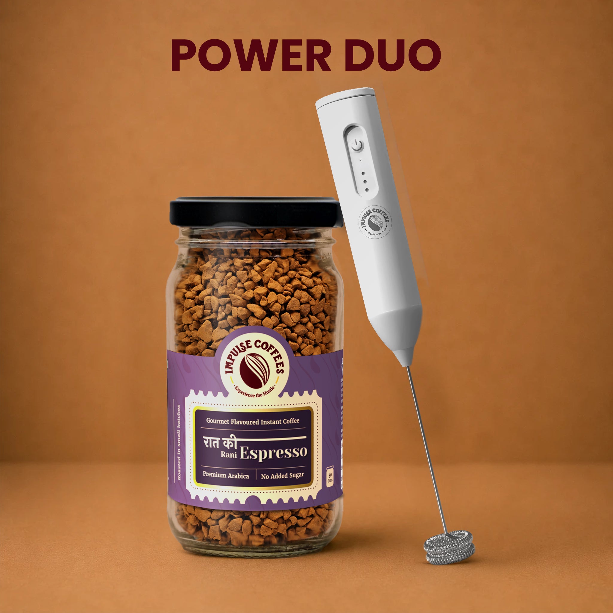 Impulse Coffees Whip's Express Power Duo bundle showcasing a premium glass jar of Raat Ki Rani Espresso gourmet flavoured instant coffee standing next to a white electronic rechargeable milk frother against a warm brown studio background.