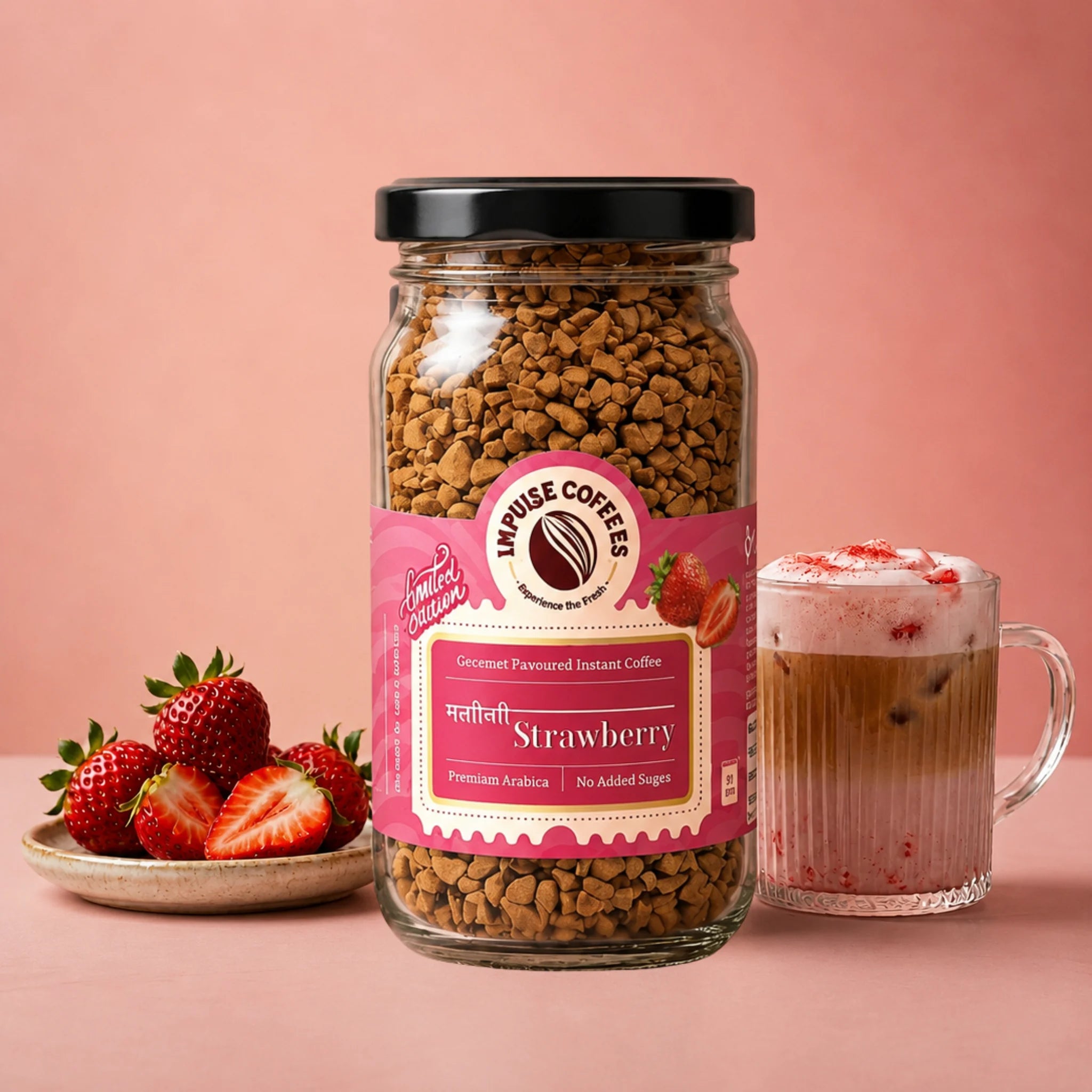 Impulse Coffees Mastibhari Strawberry flavored instant coffee 50g jar on a pink studio backdrop, surrounded by floating whole strawberries, strawberry halves, and roasted coffee beans.