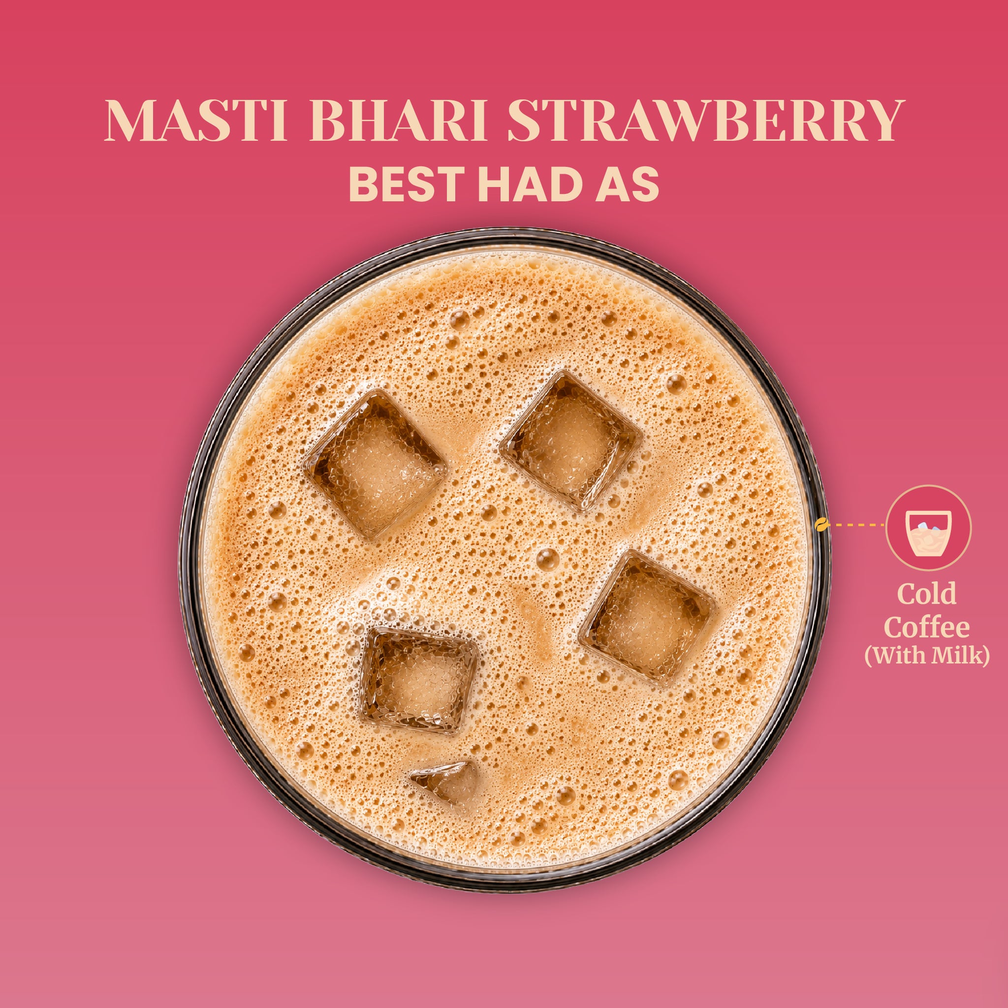 Top-down overhead view of a circular glass displaying the optimal cold preparation style for Masti Bhari Strawberry coffee. The glass shows a frothy, bubbling Cold Coffee brew with milk poured over large square ice cubes, framed against a solid pink background.