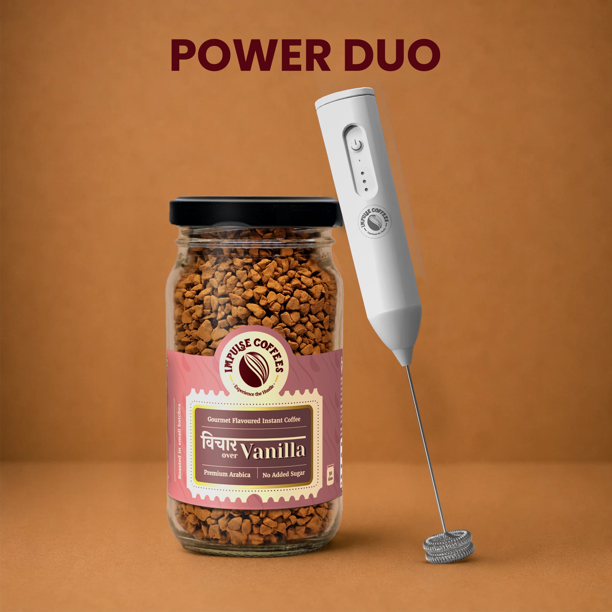 Impulse Coffees Vanilla Whip Power Duo bundle showcasing a premium glass jar of Vichaar Over Vanilla gourmet flavoured instant coffee standing next to a white electronic rechargeable milk frother against a warm brown studio background.